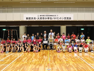 新居浜市・大府市小学生バドミントン交流会で記念撮影をする市長